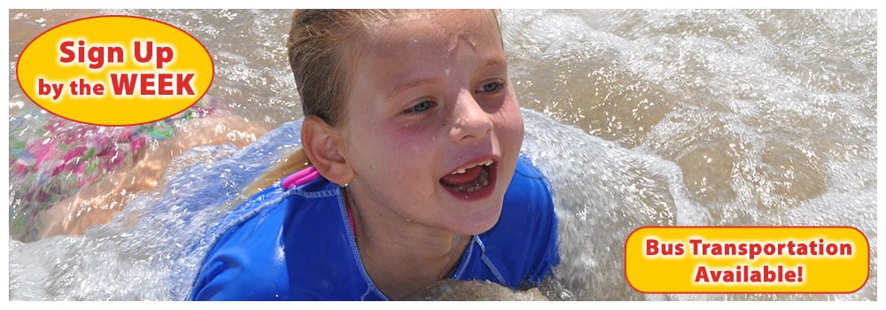 girl with missing front teeth plays in the shallow beach water